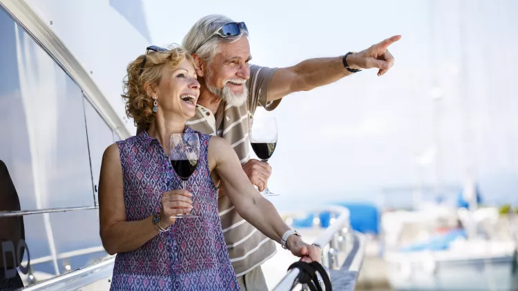 Happy senior couple enjoying wine on yacht