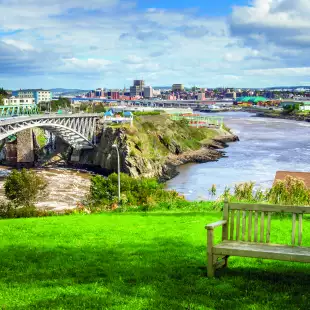 Wooden bench with the Reversing Falls bridge in Saint John city, Canada