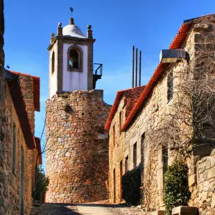 Medieval clock tower amidst a street of Castelo Rodrigo's historical village, Portugal