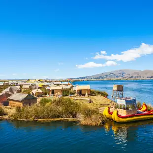 The floating islands on Titicaca Lake, featuring moored kayaks and wooden cabins