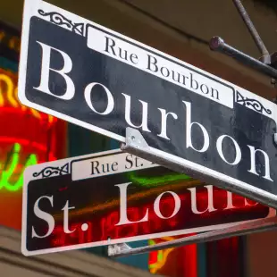 Street sign from in New Orleans, that is focused on the text saying Bourbon