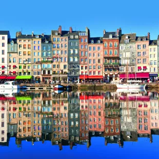 High, narrow, timber-frame houses of all colours which overlook The Port of Honfluer, a harbour located in the Norman town of Honfleur, France