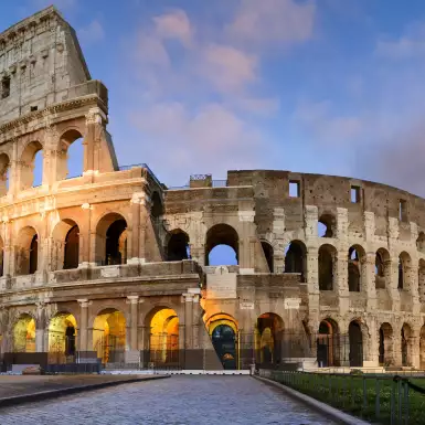 Image of the historical Colosseum in Rome against a sunset sky