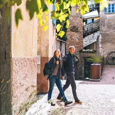 Mature couple walking and holding hands through a sunny European city