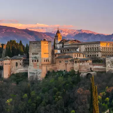 Arabic palace Alhambra with Sierra Nevada mountains in the background at twilight in Granda, Spain