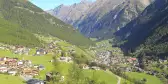 Large green hills with houses along the edges, in Soelden