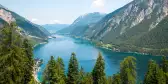 Alpine lake with fir trees and distant mountains  in Tyrol, Austria