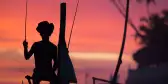 Silhouette of fisherman on a stilt with colourful sky in Ahangama village, Sri Lanka