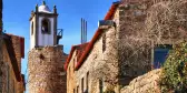 Medieval clock tower amidst a street of Castelo Rodrigo's historical village, Portugal