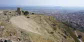 A steep hillside with rows of steps forming the ruins of the Theater of Pergamon, Turkey