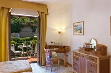 Interior of double standard bedroom with a balcony view at the Grand Hotel President in Sorrento