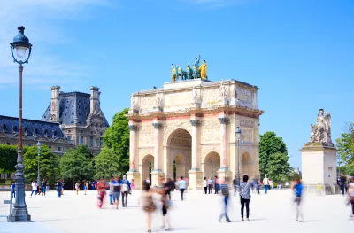 Blurred tourists and The Arc de Triomphe du Carrousel, Paris