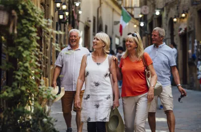 Mature couples looking around old town Italy as evening draws in.  Little lights can be seen outside of the buildings.