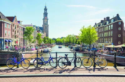 A view over a canal from a bridge with bicycles, boats and the Westerkerk in the back, Amsterdam.