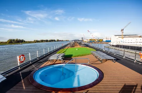 Sun deck with mini golfing area and round pool aboard the Thomas Hardy ship