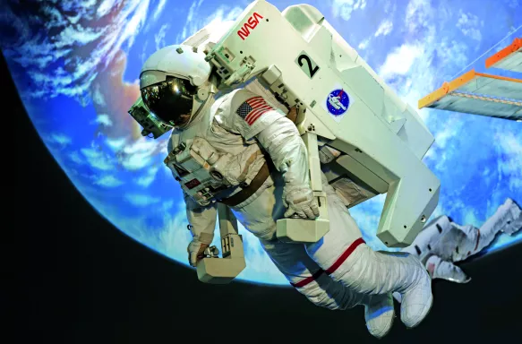 Floating astronaut in a white space suit with the earth behind them