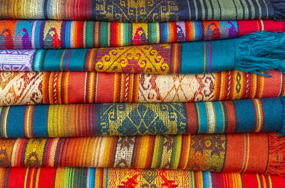 A pile of colorful Andes textiles on the sunday art and craft market of Otavalo in Ecuador, north of Quito.