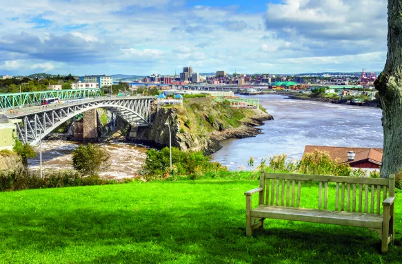 Wooden bench with the Reversing Falls bridge in Saint John city, Canada