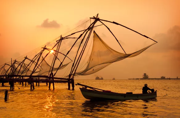 A sunset over fishing nets and boat in Cochin (Kochi), India