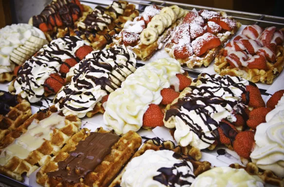 Selection of Belgian waffles with various fruit, cream and sauce