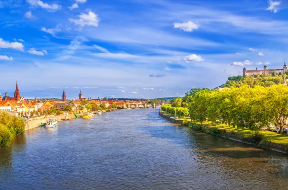 Elevated view over the river Main, the skyline of Würzburg with its churches and the historic Old Mian Bridge.