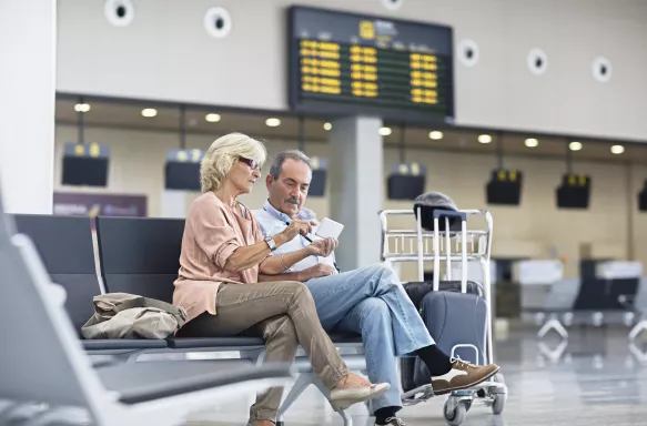 Senior Couple looking at the mobile phone at the airport