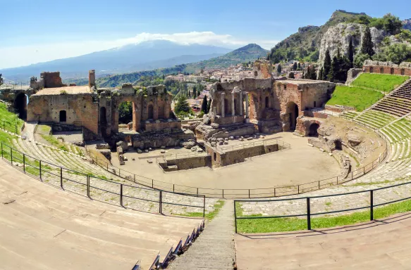 Ancient greek theatre ruins with views of Mount Etna in Taormina, Italy