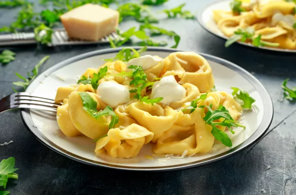 Close-up of ravioli with Parmesan and wild rocket on plate.