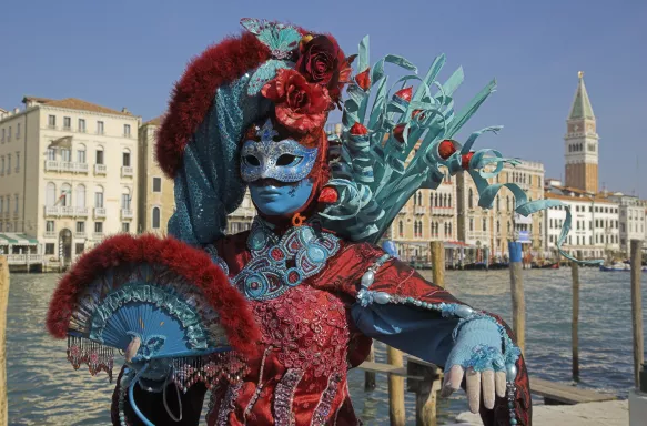 Masked female in a colourful costume at a carnival in Venice, Italy