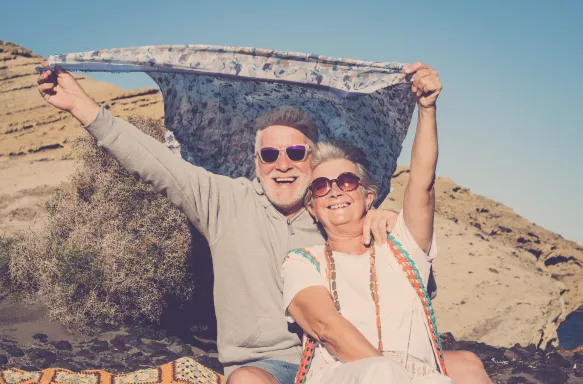 Happy senior couple outdoor, playing with the wind and smiling