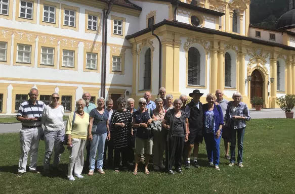 Tour group smiling and posing in front of the Stams Abbey in Austrian Tyrol