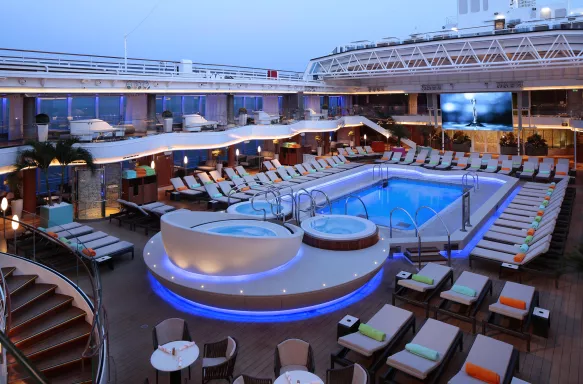 Outdoor lido pool and hot tub with sun loungers aboard the MS Koningsdam cruise ship