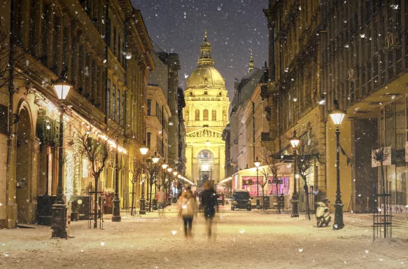 Illuminated cityscape of Zrinyi Street on a snowy winter day in Budapest