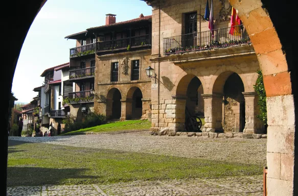 View of Santillana del Mar main square from an archway in Spain