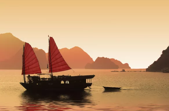 Junk boat at sunset in Halong Bay, Vietnam