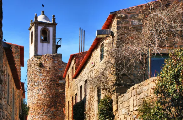 Medieval clock tower amidst a street of Castelo Rodrigo's historical village, Portugal