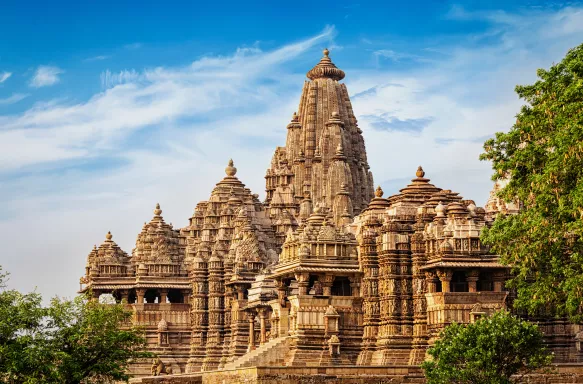 Kandariya Mahadev Temple against a bright, cloudy sky in Khajuraho, India.