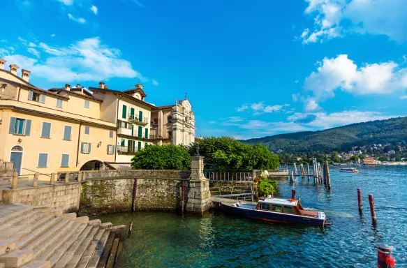 Landscape of Lake Maggiore, Stresa, Italy. With a staircase leading into the river and a small boat.