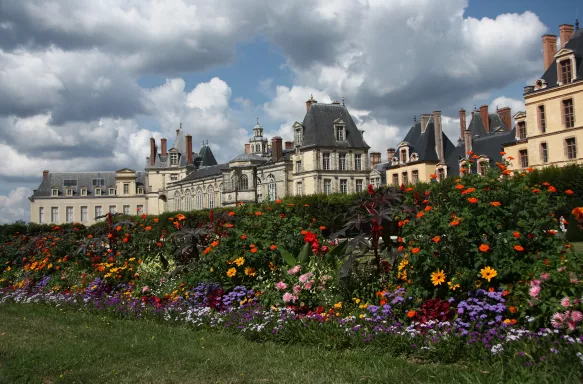 Palace of Fontainebleau and garden of colourful flowers in France