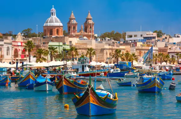 Traditional colourful eyed boats Luzzu at harbour in Marsaxlokk, Malta