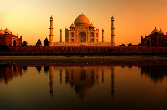 Taj Mahal at sunset with golden sky being reflected in water, Agra, India