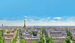 A view of Paris rooftops with the Eifel Tower on the horizon