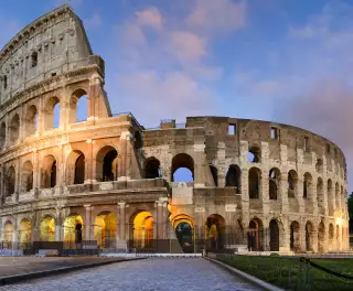 Image of the historical Colosseum in Rome against a sunset sky