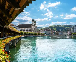 Jesuitenkirche Rathaussteg bridge over blue water with buildings in the background, Lucerne, Swizerland