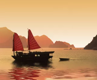 Junk boat at sunset in Halong Bay, Vietnam