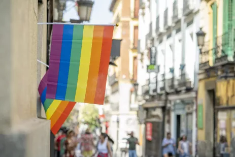 A rainbow gay pride flag hanging in the streets of Madrid